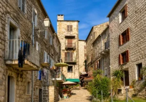 Vue panoramique sur un village corse avec maisons typiques et horizon marin