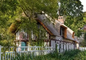 Immobilier en Normandie : Rouen, Caen, Le Havre… les villes où le marché est en train de changer 5 Cottage champêtre idyllique entouré d'arbres luxuriants et de verdure au bord de la rivière.